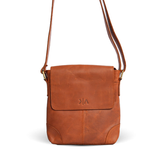 Vintage brown leather crossbody bag with a flap front and embossed logo, front view
